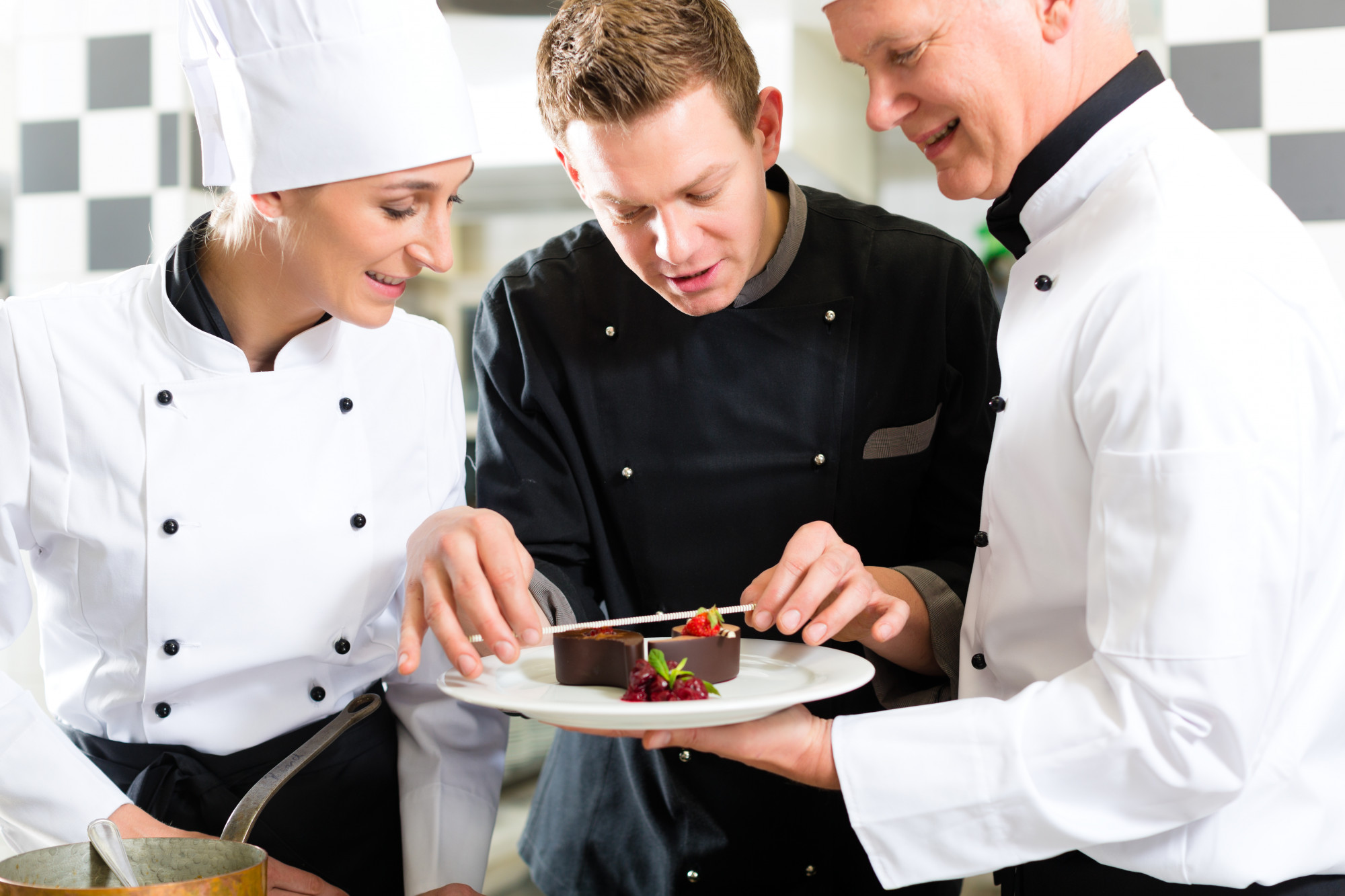 Cook demonstrating plating to a small team